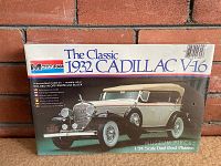 Photo of factory sealed box showing front artwork of the Monogram 1932 Cadillac V-16 plastic model kit, featuring the assembled dual cowl phaeton car model in off-white and black.