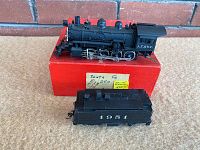 Steam locomotive and tender displayed on red box