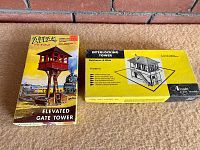 Photo shows two vintage HO scale model building kits in opened original boxes: Atlas Elevated Gate Tower and Alexander Interlocking Tower Baltimore & Ohio.