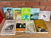 Overview of all 9 fishing books arranged on a surface, showing condition and variety.