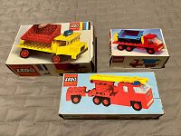 Three vintage LEGO kits in original boxes, showcasing front box art with assembled vehicles in red, yellow, blue colors on plain backgrounds.