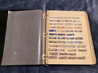 Stockbook open showing one page filled with complete rows of various vintage stamps, mainly blue and purple hues, featuring architectural designs.