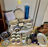 Overview of most items showing blue and white serving bowls, cups, plates, cobalt blue vase, and Carso clock