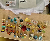 Collection of souvenir magnets and pens displayed on a table, showing variety and quantity.
