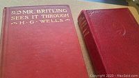 Photo of two vintage first edition H.G. Wells hardcover books with red covers, gold embossed text on front and spine.