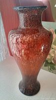 Side view of the red-orange brown Art Deco glass vase showing speckled pattern and flared top rim.