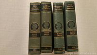 Four vintage Mark Twain books upright showing spine titles and volume numbers.