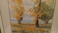 Close-up of the watercolour artwork depicting trees in autumn by Okanagan Lake, BC, showing detailed brush strokes and artist signature.