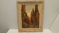 Full view of the framed oil landscape painting featuring a path and trees with autumn foliage, signed by Fabi in lower right.