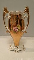 Front view of ornate Italian porcelain vase showing gold accents and raised rose decoration