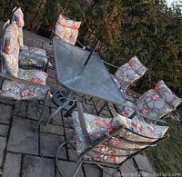 Full view of glass top table surrounded by six chairs and umbrella