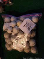 Clear plastic zippered bag containing 40 used white golf range balls with visible brand markings.