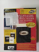 Photo of boxed product packaging showing description and images of the Colonial Series mailbox with decorative plaques.
