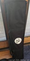 Closed black fabric carry bag with propeller emblem