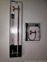 Photo of packaged 18 inch towel bar and toilet paper holder set in original packaging with visible hardware mounts and polished nickel finish.
