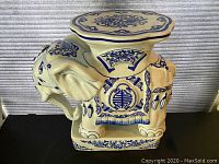 Front left angle view showing detailed blue painted floral and geometric patterns on porcelain elephant statue stand.