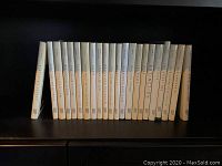Side view of 22 hardback science books showing titles on spines, arranged upright on a shelf.