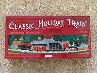 Box with Classic Holiday Train printed, showing illustrated train around a tree and product title.