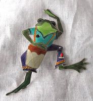Front view of a colorful frog-shaped brooch with detailed enamel work and articulated legs, showing the whimsical design and bright colors.