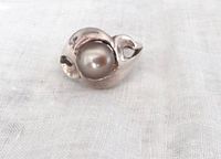 Front angled view of the vintage sterling silver ring with a large grey mabe pearl set in a modern sculptural design.