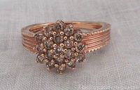 Front view of sterling silver ring plated with rose gold featuring a cluster of champagne diamonds on the top.