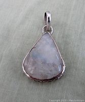 Front view of triangular moonstone pendant set in sterling silver with large bail.
