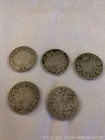 Reverse side of five Canadian dimes showing wreath designs and dates on some coins