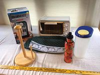 Overview of lot items including Deskmate mini fridge box, small toaster oven, paper towel holder, fabric oven mitt, plastic container, and water bottle