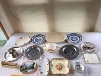 Overview of multiple plates and serving dishes on a white tablecloth showing variety and condition.