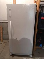 Front view of upright freezer showing exterior and curved handle