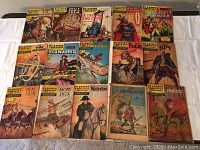 Photo showing 15 Classics Illustrated comic books laid out on a white surface, featuring various covers from vintage series.