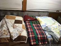 Three handmade quilts laid side by side on a flat surface.