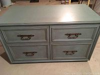 Front view of vintage blue dresser showing four drawers with metal handles