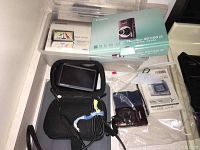 Photo shows Canon PowerShot SD1100 IS camera, Garmin nüvi 255WT GPS, their boxes, and accessories including GPS soft case and cables.