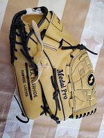 Side view of the tan and black SSK Medal Pro baseball glove highlighting the U.S.A. S. Pride Ramhide Lacing branding on the thumb area.