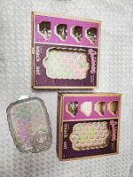 Two boxed sets of vintage iridescent glass snack sets with trays and mugs visible.