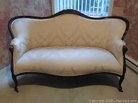 Full front view of the settee resting against wall