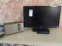 Photo showing Toshiba 23 inch TV next to Radio Shack MTA-16 radio on table.