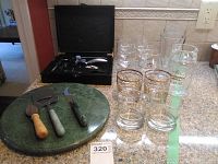 Full lot shown on countertop: corkscrew kit in open black case, marble cheese board with cheese cutting tools, and various glass tumblers arranged