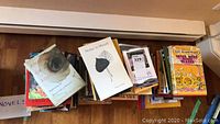 Photo showing a pile of various novels and books including The Woman in White and Notes to Myself