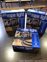 Three unopened boxes of LED rope lighting 18 ft each, showing packaging with blue design and usage images