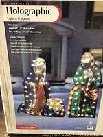 Box photo showing three-piece holographic nativity set including Mary, Joseph, and Baby Jesus.