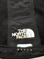 Close-up of The North Face logo on the backpack strap.