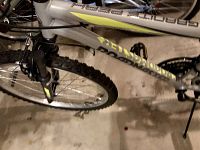 Close-up of front tire, suspension fork, and pedal showing knobby tire tread and Roadmaster logo on frame