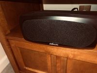 Front view of the larger center Polk Audio speaker showing black fabric grille and Polk Audio branding