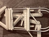 Folded rescue ladder with visible metal rails and white plastic steps arranged on carpet.