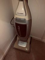 Full view of beige and burgundy Electrolux Versatility upright vacuum cleaner with 'hand turbo' labeling on handle.