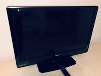 Full front view of Philips 32 inch LCD television showing black frame and screen on stand.