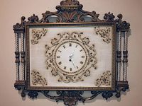 Full view of the rectangular ornate wall clock with detailed carved frame, twisted columns, and floral scroll designs.