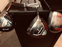 Four club heads hanging including Callaway Big Bertha Fusion FT-3, Titleist 3-iron, Power Bilt driver, and Callaway X2 Hot driver